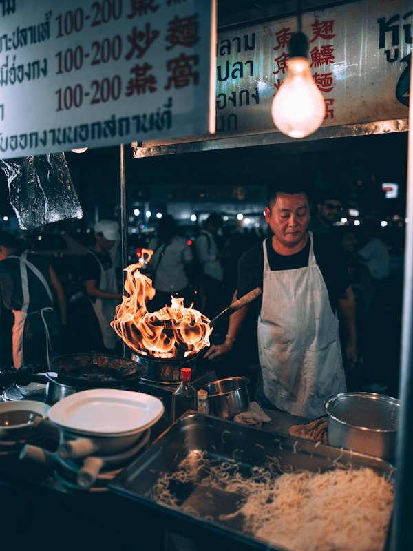 Cook working at a Bangkok street food stall