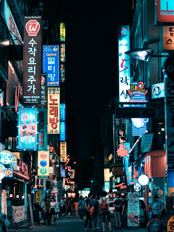 Narrow street in Seoul lined with glowing signs