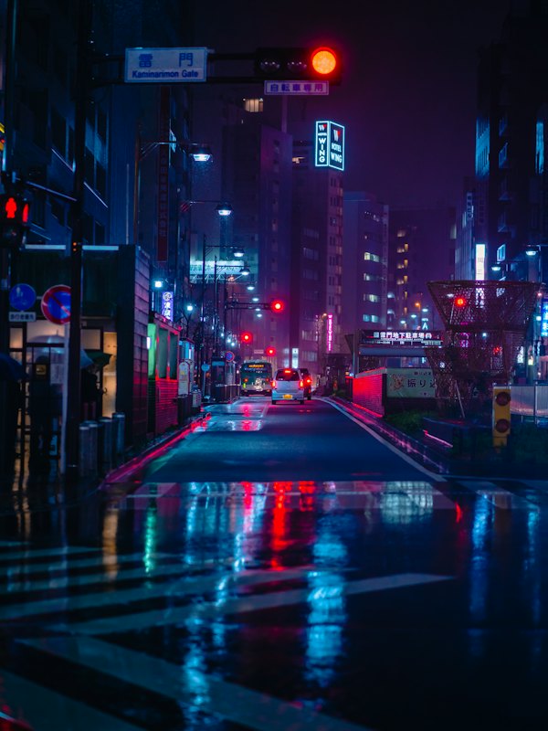 Wet street at night in Tokyo with neon signs